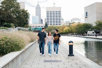 3 students talking and walking along the Indianapolis canal