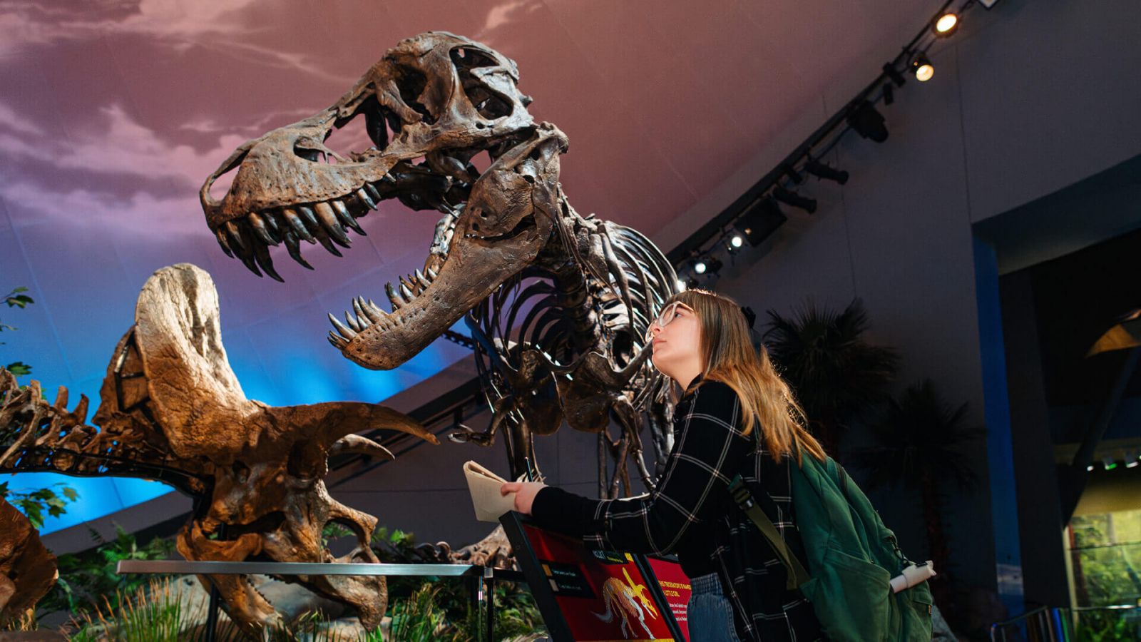 Carys George with dinosaur skeletons